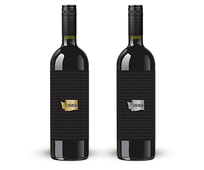 1889-btl graphic Two dark wine bottles with black labels, each showcasing an elegant 1889 badge—one in gold and the other in silver.