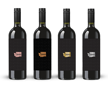 Four wine bottles with black labels, each featuring a gold, rose gold, or silver shape and 1889 text.