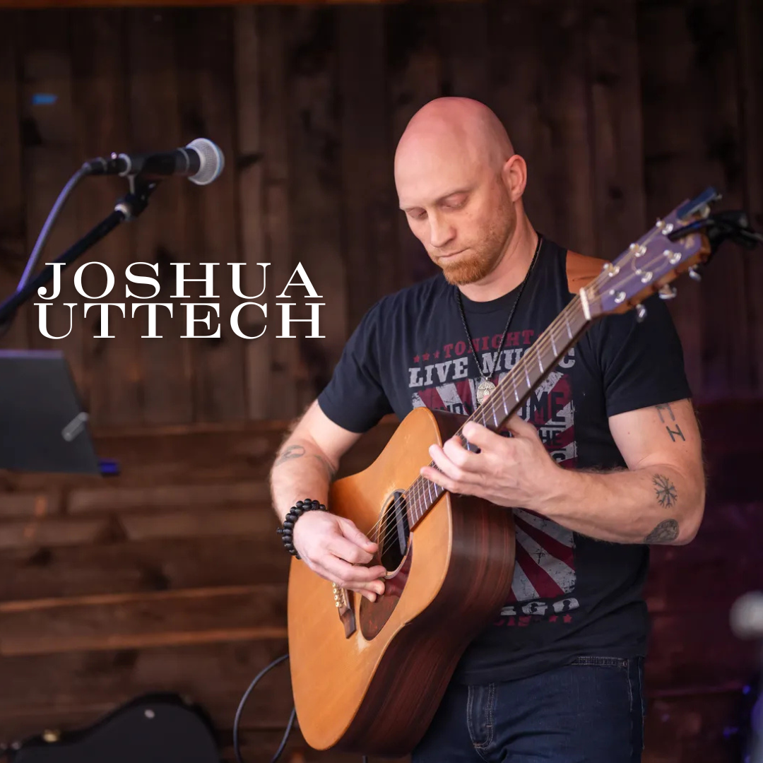 A bald man plays an acoustic guitar on stage with Joshua Uttech written beside him.