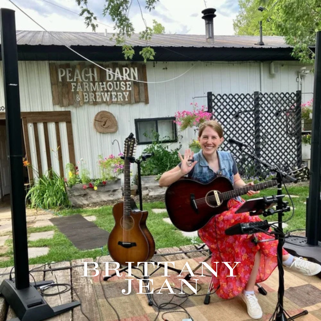 Woman with guitar waves, seated outdoors on stage at Peach Barn Farmhouse & Brewery. Text: BRITTANY JEAN.